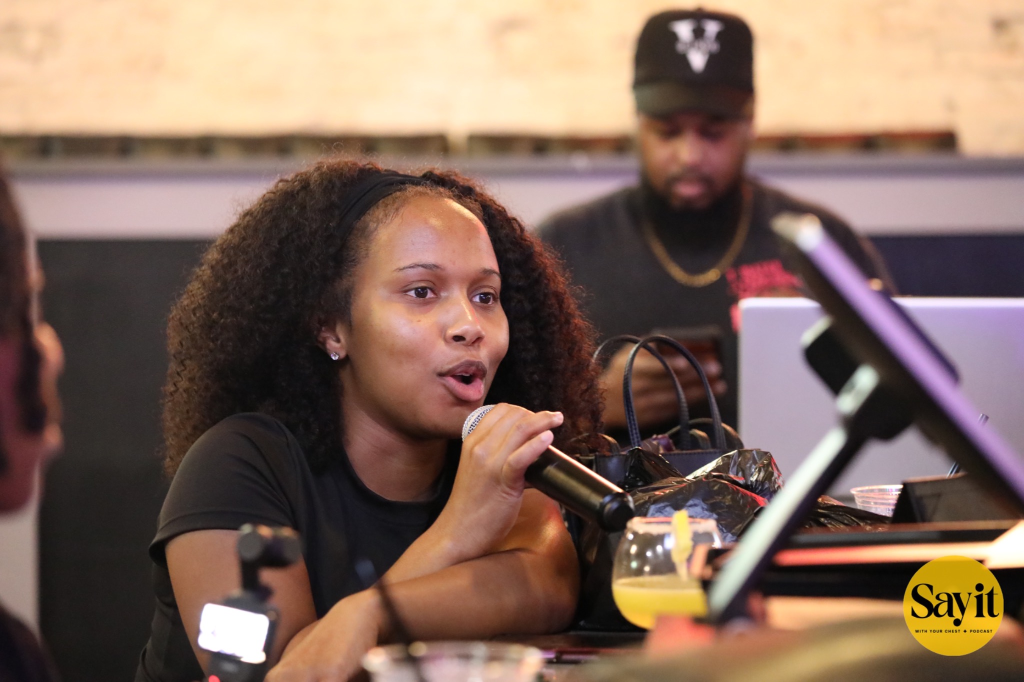 An audience member sharing her perspective into a microphone